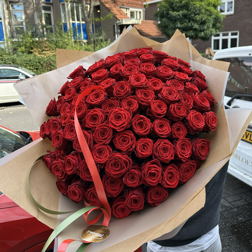 Indrukwekkend boeket van 100 dieproode Red Naomi rozen van Pasmans Bloemen in Eindhoven.